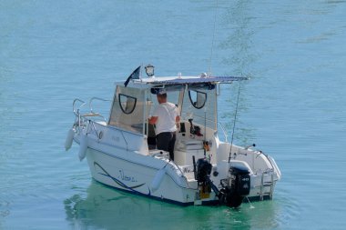 İtalya, Sicilya, Akdeniz, Marina di Ragusa (Ragusa Eyaleti); 8 Kasım 2022, limandaki bir motorlu teknede balıkçı - EDITORIAL