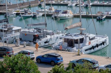 İtalya, Sicilya, Akdeniz, Marina di Ragusa (Ragusa Eyaleti); 16 Kasım 2022, limanda insanlar, arabalar ve lüks yatlar - EDITORIAL