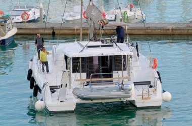 Taly, Sicilya, Akdeniz, Marina di Ragusa (Ragusa Eyaleti); 15 Kasım 2022, limandaki bir yelkenli teknesinde erkekler - EDITORIAL