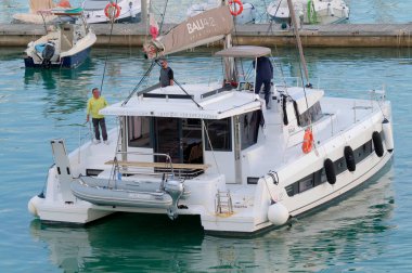 Taly, Sicilya, Akdeniz, Marina di Ragusa (Ragusa Eyaleti); 15 Kasım 2022, limandaki bir yelkenli teknesinde erkekler - EDITORIAL