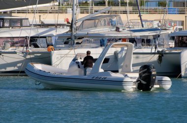 İtalya, Sicilya, Akdeniz, Marina di Ragusa (Ragusa Eyaleti); 24 Kasım 2022, limandaki kauçuk tekne ve lüks yatlarda erkekler - EDITORIAL