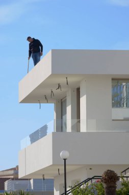 İtalya, Sicilya, Akdeniz, Marina di Ragusa (Ragusa Eyaleti), 24 Kasım 2022, çatıda çalışan adam - EDITORIAL