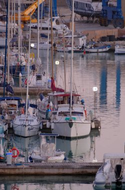 İtalya, Sicilya, Akdeniz, Marina di Ragusa (Ragusa Eyaleti); 5 Aralık 2022, gün batımında limanda motorlu tekne ve lüks yatlar - EDITORIAL