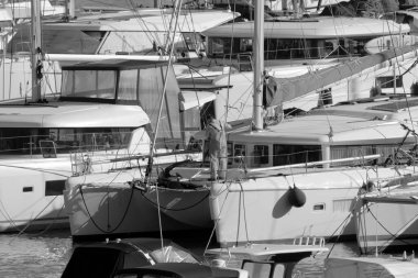 İtalya, Sicilya, Akdeniz, Marina di Ragusa (Ragusa Eyaleti); 8 Aralık 2022, limandaki bir yelkenli ve lüks yatlarda adam - EDITORIAL