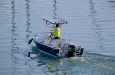 İtalya, Sicilya, Akdeniz, Marina di Ragusa (Ragusa Eyaleti); 18 Aralık 2022, limandaki bir motorlu teknede balıkçı - EDITORIAL