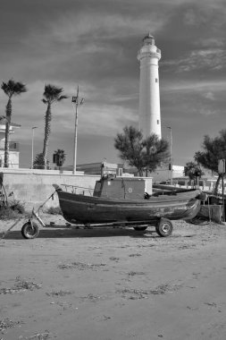 İtalya, Sicilya, Akdeniz, Punta Secca (Ragusa Eyaleti), deniz feneri manzarası ve sahilde bir balıkçı teknesi