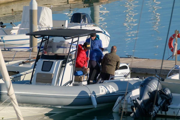 İtalya, Sicilya, Akdeniz, Marina di Ragusa (Ragusa Eyaleti); 31 Aralık 2022, limandaki lastik bir teknede balıkçılar - EDITORIAL