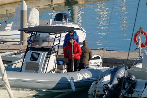 İtalya, Sicilya, Akdeniz, Marina di Ragusa (Ragusa Eyaleti); 31 Aralık 2022, limandaki lastik bir teknede balıkçılar - EDITORIAL