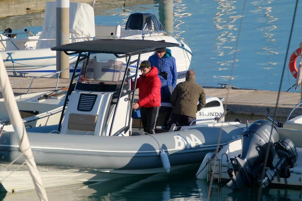 İtalya, Sicilya, Akdeniz, Marina di Ragusa (Ragusa Eyaleti); 31 Aralık 2022, limandaki lastik bir teknede balıkçılar - EDITORIAL