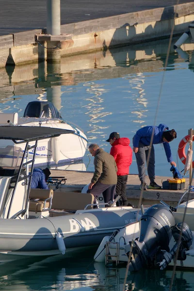 İtalya, Sicilya, Akdeniz, Marina di Ragusa (Ragusa Eyaleti); 31 Aralık 2022, limandaki lastik bir teknede balıkçılar - EDITORIAL