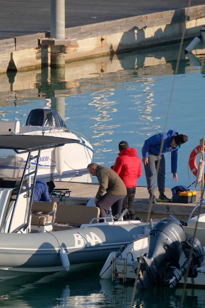 İtalya, Sicilya, Akdeniz, Marina di Ragusa (Ragusa Eyaleti); 31 Aralık 2022, limandaki lastik bir teknede balıkçılar - EDITORIAL