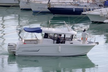 İtalya, Sicilya, Akdeniz, Marina di Ragusa (Ragusa Eyaleti); 6 Ocak 2023, limandaki bir motorlu teknede balıkçı - EDITORIAL