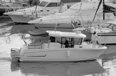 İtalya, Sicilya, Akdeniz, Marina di Ragusa (Ragusa Eyaleti); 6 Ocak 2023, limandaki bir motorlu teknede balıkçı - EDITORIAL