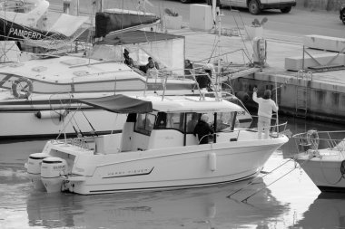 İtalya, Sicilya, Akdeniz, Marina di Ragusa (Ragusa Eyaleti); 6 Ocak 2023, limandaki bir motorlu teknede balıkçı - EDITORIAL