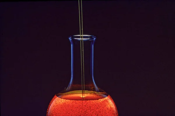 Industrial oil pouring in a glass container