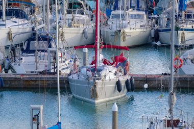 Italy, Sicily, Mediterranean Sea, Marina di Ragusa (Ragusa Province); 27 January 2023, men on a sailing boat and luxury yachts in the port - EDITORIAL