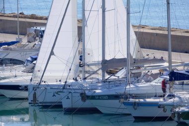 İtalya, Sicilya, Akdeniz, Marina di Ragusa (Ragusa Eyaleti); 1 Şubat 2023, limandaki yelkenli teknelerinde erkekler - EDITORIAL