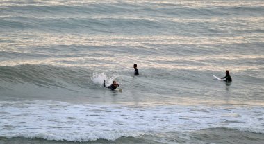Italy, Sicily, Mediterranean Sea, Marina di Ragusa (Ragusa Province); 11 February 2023 surfers swimming ashore - EDITORIAL 