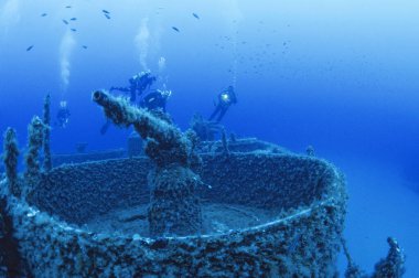 ITALY, Mediterranean Sea, Ponza Island; view of a cannon on the wreck of a sunken ship and scuba divers (FILM SCAN)