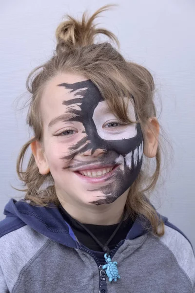 portrait of a 6 years old male child with a painted face for Carnival
