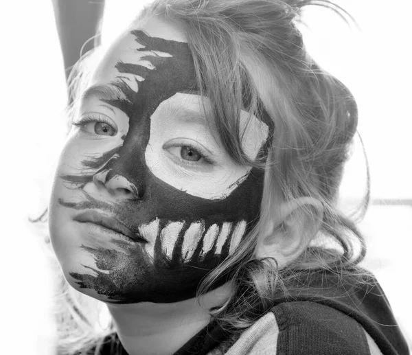portrait of a 6 years old male child with a painted face for Carnival