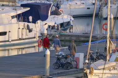 Italy, Sicily, Mediterranean sea, Marina di Ragusa (Ragusa Province); 21 February 2023, people and luxury yachts in the port at sunset - EDITORIAL