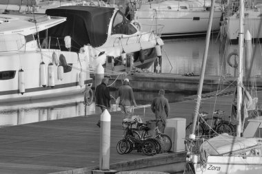 Italy, Sicily, Mediterranean sea, Marina di Ragusa (Ragusa Province); 21 February 2023, people and luxury yachts in the port at sunset - EDITORIAL