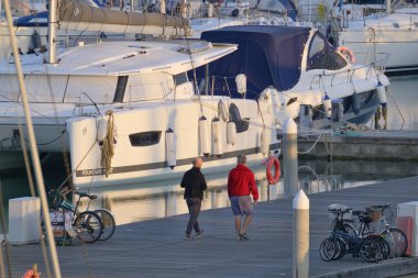 Italy, Sicily, Mediterranean sea, Marina di Ragusa (Ragusa Province); 21 February 2023, people and luxury yachts in the port at sunset - EDITORIAL