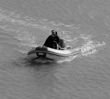 Italy, Sicily, Mediterranean Sea, Marina di Ragusa (Ragusa Province); 5 March 2023, men on a rubber boat in the port - EDITORIAL