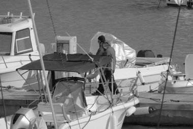 İtalya, Sicilya, Akdeniz, Marina di Ragusa (Ragusa Eyaleti); 5 Mart 2023, limandaki insanlar ve lüks yatlar - EDITORIAL