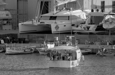 İtalya, Sicilya, Marina di Ragusa (Ragusa Eyaleti), 9 Mart 2023, limanda yerel balıkçı tekneleri ve lüks yatlar - EDITORIAL