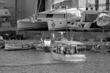 İtalya, Sicilya, Marina di Ragusa (Ragusa Eyaleti), 9 Mart 2023, limanda yerel balıkçı tekneleri ve lüks yatlar - EDITORIAL