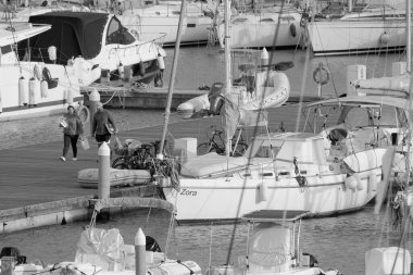 İtalya, Sicilya, Akdeniz, Marina di Ragusa (Ragusa Eyaleti); 10 Mart 2023, limandaki insanlar ve lüks yatlar - EDITORIAL