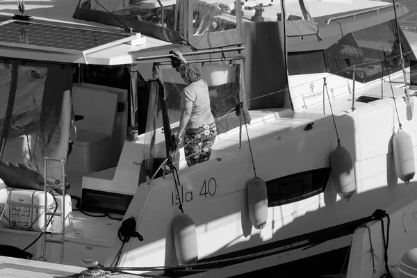 İtalya, Sicilya, Akdeniz, Marina di Ragusa (Ragusa Eyaleti); 13 Mart 2023, limandaki bir yelkenli teknesinde kadın - EDITORIAL