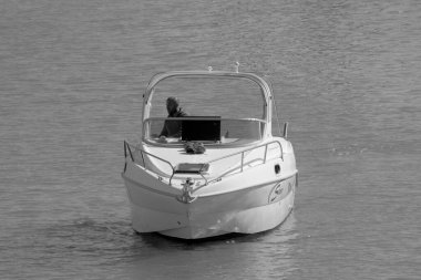 İtalya, Sicilya, Akdeniz, Marina di Ragusa (Ragusa Eyaleti); 17 Mart 2023, limandaki bir motorlu teknede adam - EDITORIAL