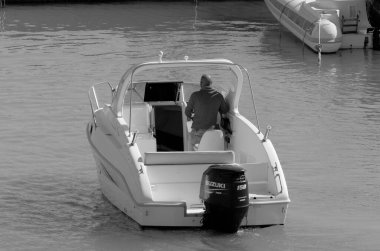 İtalya, Sicilya, Akdeniz, Marina di Ragusa (Ragusa Eyaleti); 17 Mart 2023, limandaki bir motorlu teknede adam - EDITORIAL