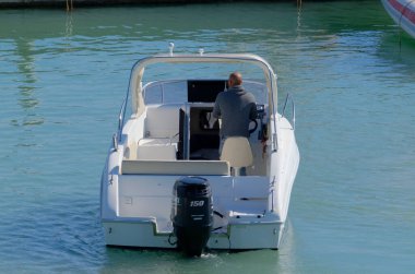 İtalya, Sicilya, Akdeniz, Marina di Ragusa (Ragusa Eyaleti); 17 Mart 2023, limandaki bir motorlu teknede adam - EDITORIAL