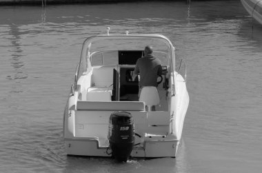 İtalya, Sicilya, Akdeniz, Marina di Ragusa (Ragusa Eyaleti); 17 Mart 2023, limandaki bir motorlu teknede adam - EDITORIAL