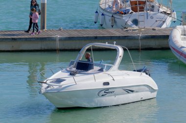 İtalya, Sicilya, Akdeniz, Marina di Ragusa (Ragusa Eyaleti); 17 Mart 2023, limandaki bir motorlu teknede adam - EDITORIAL