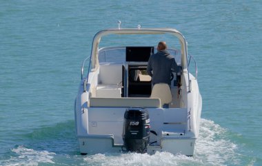 İtalya, Sicilya, Akdeniz, Marina di Ragusa (Ragusa Eyaleti); 17 Mart 2023, limandaki bir motorlu teknede adam - EDITORIAL