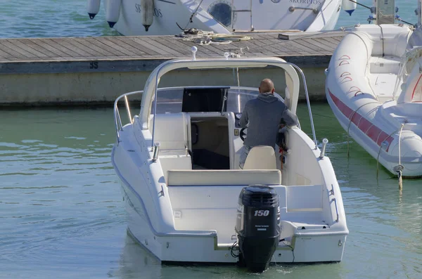 stock image Italy, Sicily, Mediterranean Sea, Marina di Ragusa (Ragusa Province); 17 March 2023, man on a motor boat in the port - EDITORIAL