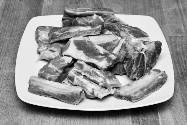 未经煮熟的猪肉排骨上一个白盘子里 — 图库照片