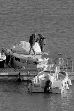 İtalya, Sicilya, Akdeniz, Marina di Ragusa (Ragusa Eyaleti); 25 Mart 2023, limanda lüks bir yatta insanlar - EDITORIAL