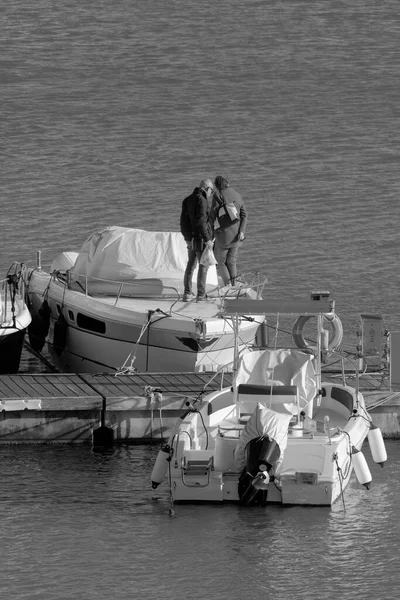 İtalya, Sicilya, Akdeniz, Marina di Ragusa (Ragusa Eyaleti), limanda lüks bir yatta yaşayan insanlar. 