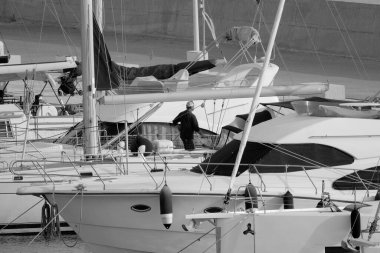 İtalya, Sicilya, Akdeniz, Marina di Ragusa (Ragusa Eyaleti), limanda bir yelkenli ve lüks yatlarda bir adam 