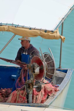 İtalya, Sicilya, Akdeniz, Marina di Ragusa (Ragusa Eyaleti); 18 Mayıs 2023; yerel balıkçı limandaki balıkçı ağlarını temizliyor - EDITORIAL