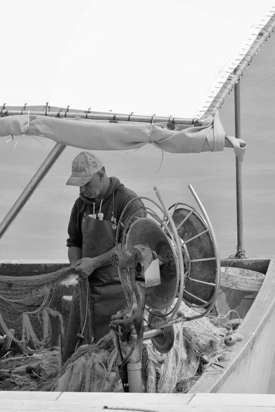 意大利 西西里 地中海 拉古萨海 拉古萨省 2023年5月18日 当地渔民在港口的一艘渔船上清理渔网 Editorial — 图库照片