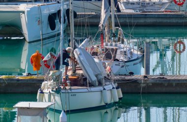 İtalya, Sicilya, Akdeniz, Marina di Ragusa (Ragusa Eyaleti); 23 Mayıs 2023, limandaki bir yelkenli teknesinde adam - EDITORIAL