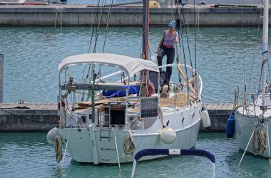 İtalya, Sicilya, Akdeniz, Marina di Ragusa (Ragusa Eyaleti); 26 Mayıs 2023, limandaki bir yelkenli teknesinde kadın - EDITORIAL