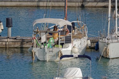 İtalya, Sicilya, Akdeniz, Marina di Ragusa (Ragusa Eyaleti); 2 Haziran 2023, limandaki bir yelkenli teknesinde adam - EDITORIAL